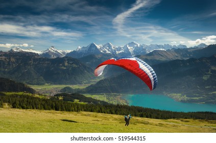 Paraglider taking off in front of spectacular Swiss scenery, Bernese Oberland, Switzerland.