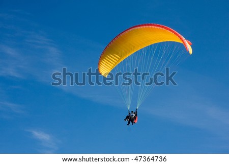 Paragliding in Bulgaria over the mountains against clear blue sky