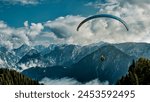 Paragliding coming in to land in the Solang Valley near Manali with mountains in the background. 