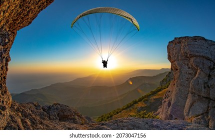 Paragliding concept, paraglider pilot fly in sky on beauty nature mountain landscape Crimea background, horizontal photo