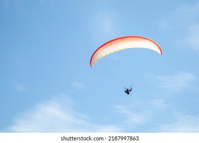 paragliding. extreme sport. a guy on a paraglider flies in the blue sky