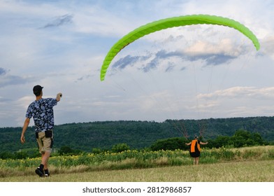 Paragliding Instructor Assisting Pilot Before Takeoff