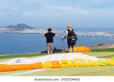 Paragliding instructor teaching a student how to use the controls of a paraglider - Powered by Shutterstock