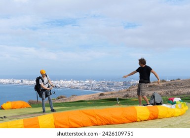 Paragliding instructor teaching a student to paraglide - Powered by Shutterstock