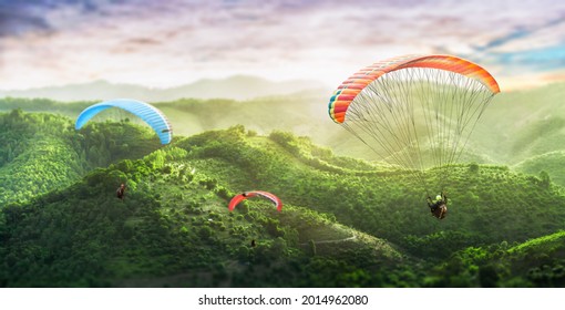 Paragliding multicolor. Paraglider flying over Landscape from the background Beauty nature mountain landscape of the sky. Paragliding Sports. Concept of extreme sport, taking adventure challenge.