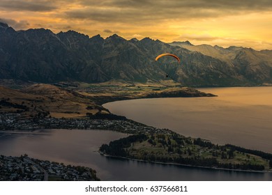 Paragliding over Queenstown and Lake Wakaitipu with The Remarkables in the background from viewpoint at Queenstown Skyline, New Zealand