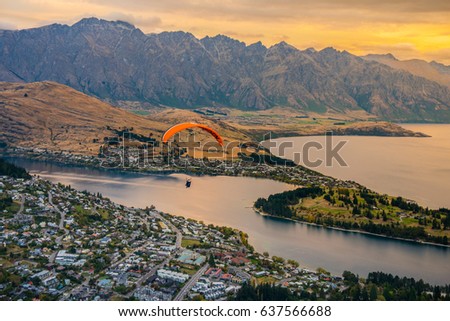 Paragliding over Queenstown and Lake Wakaitipu with The Remarkables in the background from viewpoint at Queenstown Skyline, New Zealand