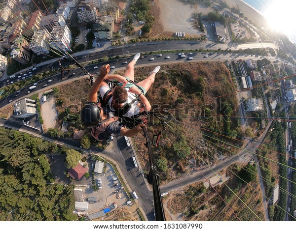 Paragliding. The sea, houses, road, cars from a\
bird\'s eye view. The city is\
below.