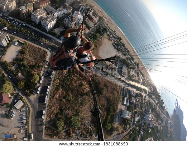 Paragliding. The sea, houses, road,\
cars from a bird\'s eye view. The city is below.\
Adrenalin.