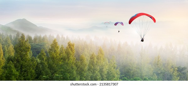 Paragliding in the sky. Paraglider  flying over Landscape sun set Concept of extreme sport, taking adventure challenge.  - Shutterstock ID 2135817307