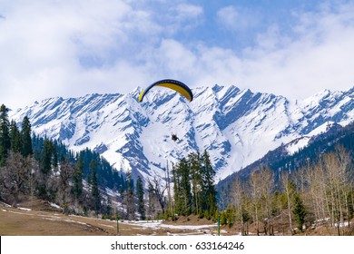 Paragliding at Solang Valley with Snow cladded mountains of Dhauladhar in background en-route to Rohtang Pass, Manali, Himachal Pradesh, India. - Shutterstock ID 633164246