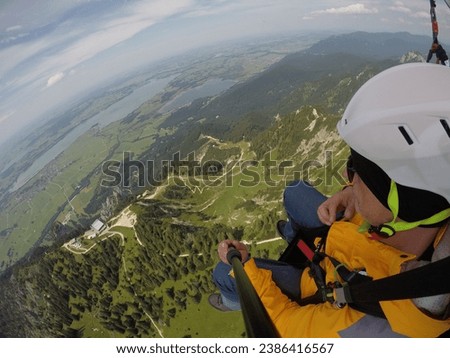 Paragliding In Tandem. People In The Sky. A Man Flying Over The Mountains. Beautiful Landscape From Above, Schwangau, Bavaria, Germany.
