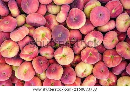 Paraguayan sweet peaches stacked in a container box to the raw for sale, overhead photo