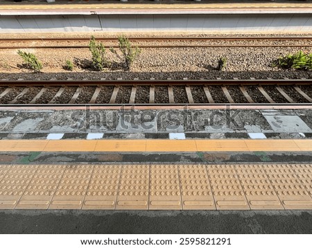 parallel lines of railroad tracks, sidewalks, guiding block, queue line and parapet walls at Bojong Indah Station, Jakarta