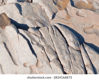 Parallel Rock Cracks Separating Slanted Stone Slabs
​A close-up top-down capture of structured coastal bedrock divided by clean, precise diagonal fissures under bright daylight