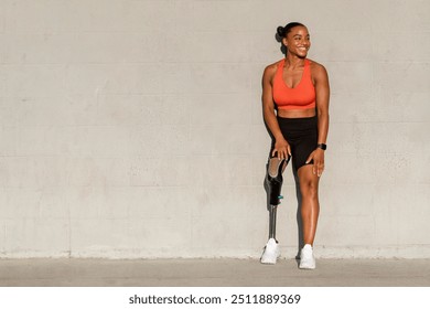 Paralympic athlete with prosthetic leg smiling by the wall - Powered by Shutterstock