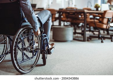 Paralyzed man in a wheelchair on the move in the disabled office building. Wheeling his way into recovery.  Businessman hand driving wheelchair. Businessman on wheelchair - Powered by Shutterstock