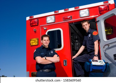 Paramedic By Door Of Ambulance By Colleague, Portrait, Low Angle View