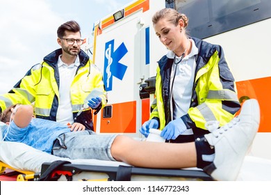 Paramedic and emergency doctor caring for injured boy on stretcher - Powered by Shutterstock