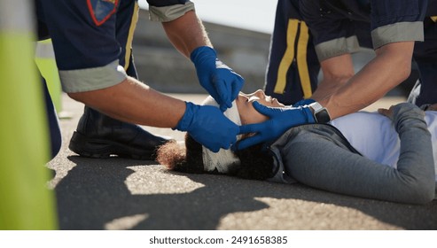 Paramedic, emergency and hands on head injury on road in car crash accident with healthcare help. EMS, wrapping bandage and first responder with victim or rescue in street to save person outdoors - Powered by Shutterstock