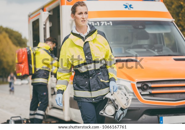 Paramedic nurse and emergency doctor at ambulance\
with kit
