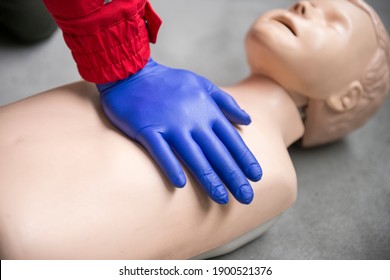 Paramedic Practicing One Hand Basic Life Support And Cpr On Child Mannequin