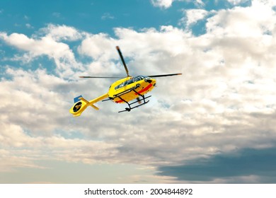 Paramedic Rescue Helicopter Against Blue Cloud Sky. Starting Helicopter, Flying Ambulances, Air Ambulance In Germany. Emergency Doctor. View From Below