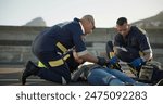 Paramedic, rescue and team with patient, outdoor and EKG to check heart, service and helping of person. EMS, accident and injury on street, healthcare and medical professional with victim in USA