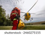 Paramedic with safety harness and climbing equipment running to helicopter of emergency medical service. Themes rescue, help and hope.
