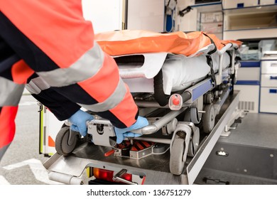 Paramedic Taking Out Stretcher From Ambulance Car