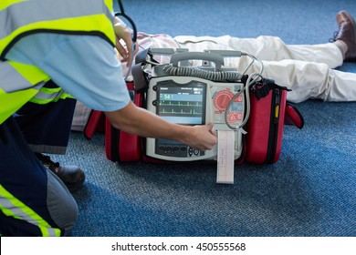 Paramedic using an external defibrillator during cardiopulmonary resuscitation in hospital