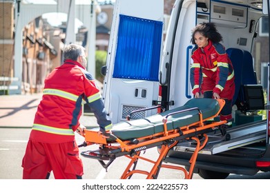 Paramedical Workers Taking A Stretcher Out Of The EMS Vehicle