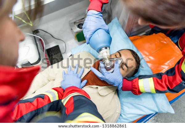Paramedics doing cardiopulmonary resuscitation in\
ambulance car
