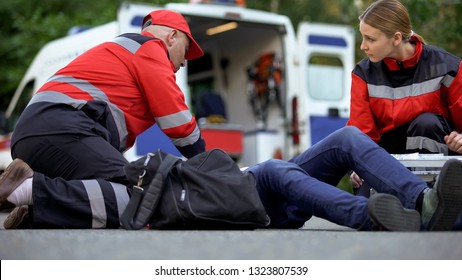 Paramedics helping patient on road, first aid trainings, medical qualification