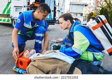 Paramedics immobilized senior patient with neck brace and spinal board to prevent damage in case of spinal injury. First aid from ambulance technicians - Powered by Shutterstock