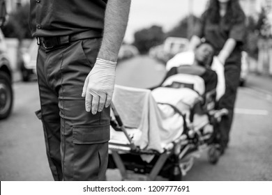 Paramedics Moving A Patient On A Stretcher To An Ambulance