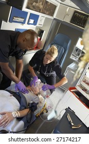 Paramedics Performing CPR On Patient In Ambulance