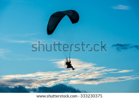 paramotor flying in the air at sunset