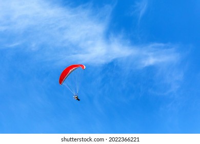 Paramotor flying in a blue sky. Adventure man active extreme sport pilot flying in sky with paramotor engine glider parachute