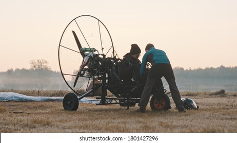 Paramotorgliding. two men preparing for the tandem paramotorgliding. 