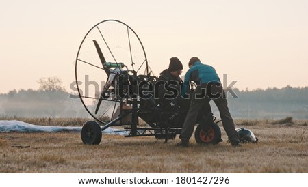 Paramotorgliding. two men preparing for the tandem paramotorgliding. 