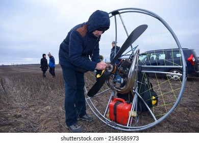 Paramotoring. Instructor helping the paramotorist Instructor helping the paramotorist to prepare equipment for flight. January 12, 2020. Kiev, Ukraine
