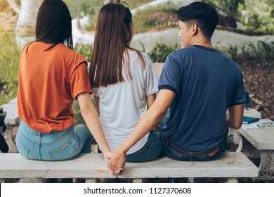 Paramour and divorce secret lovers concept, Asian couple boyfriend holding hands another woman back behind girlfriend threesome unfaithful with friends together.