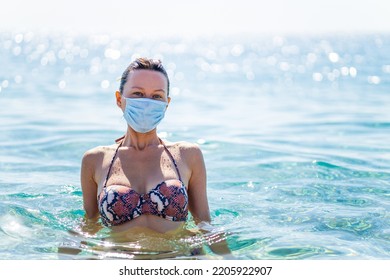 Paranoid Woman Swimming On Water With Mask On Face At Sunny Day