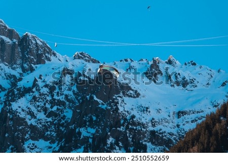 Paraplan and deltaplan in alps over a ski resort