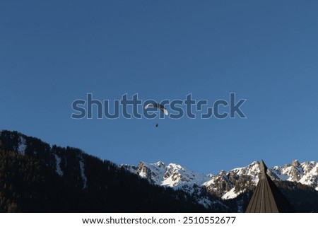 Paraplan and deltaplan in alps over a ski resort