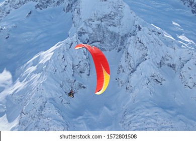 paraplane flying over snowy Caucasus mountains sunny blue sky