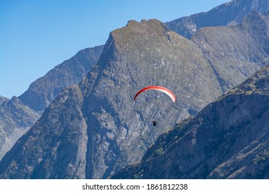 Paraplaners In Tandem Gliding In Blue Sky With View On Alpine Mountains On Paraplane