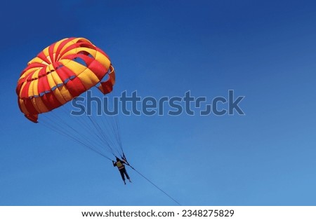 Parasailing activity on beach at sunny afternoon