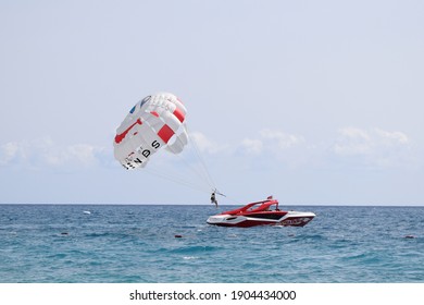 Parasailing - form of recreation, a person is fixed with a long rope to a moving boat and thanks to presence of special parachute hovers through the air. Tekirova, Antalya Turkey. 27 september, 2020